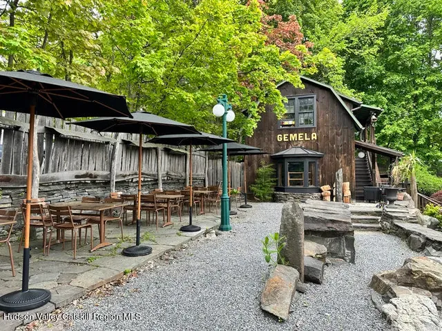 a view of backyard with seating space and wooden fence