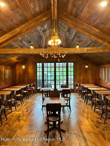 a view of a dining room with furniture a chandelier and wooden floor