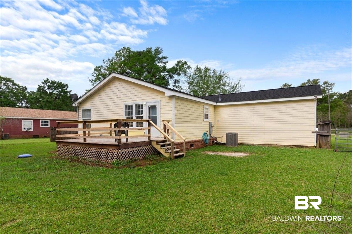 6971 March Road Theodore, AL 36582 - Photo 20 of 26 Back of property featuring fence, crawl space, a deck, central AC, and a yard
