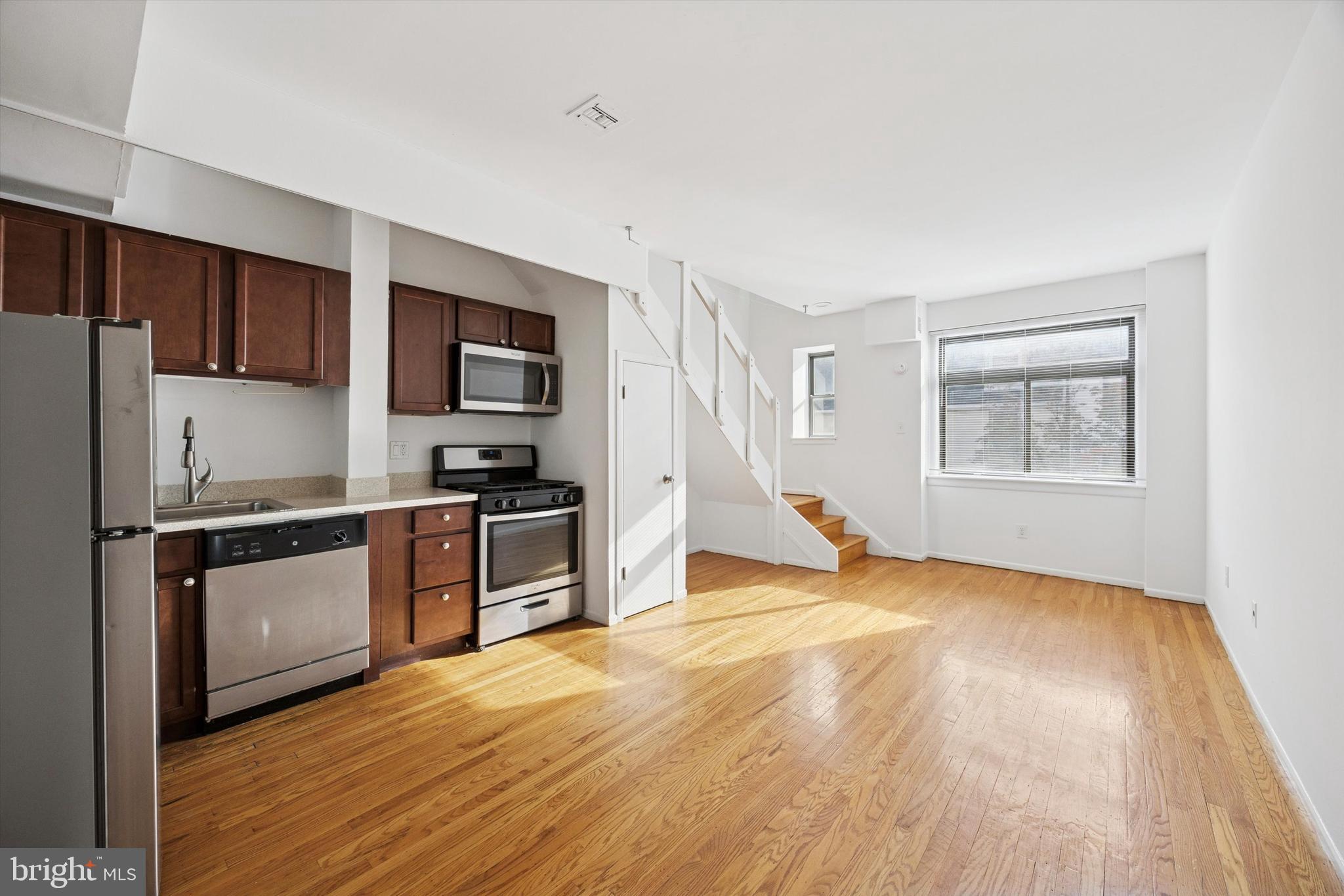 319 South 10th Street, Unit 335 Philadelphia, PA 19107 - Photo 5 of 15 a kitchen with granite countertop a refrigerator and a stove top oven