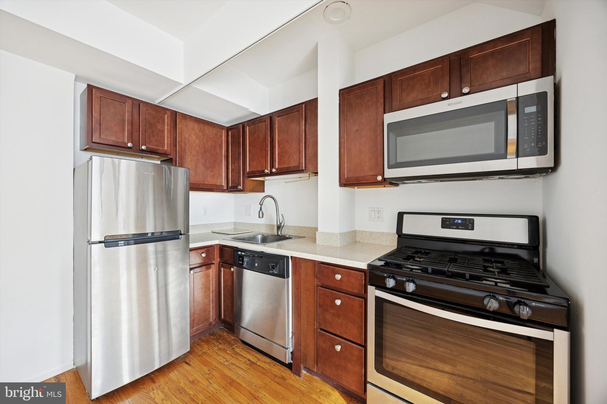 319 South 10th Street, Unit 335 Philadelphia, PA 19107 - Photo 7 of 15 a kitchen with a stove microwave and sink