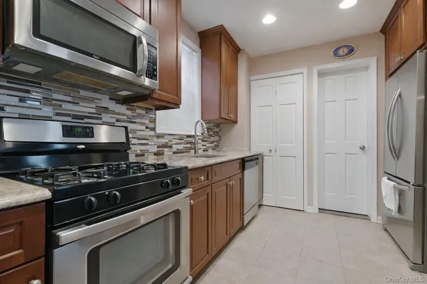 a kitchen with stainless steel appliances granite countertop a stove and a microwave