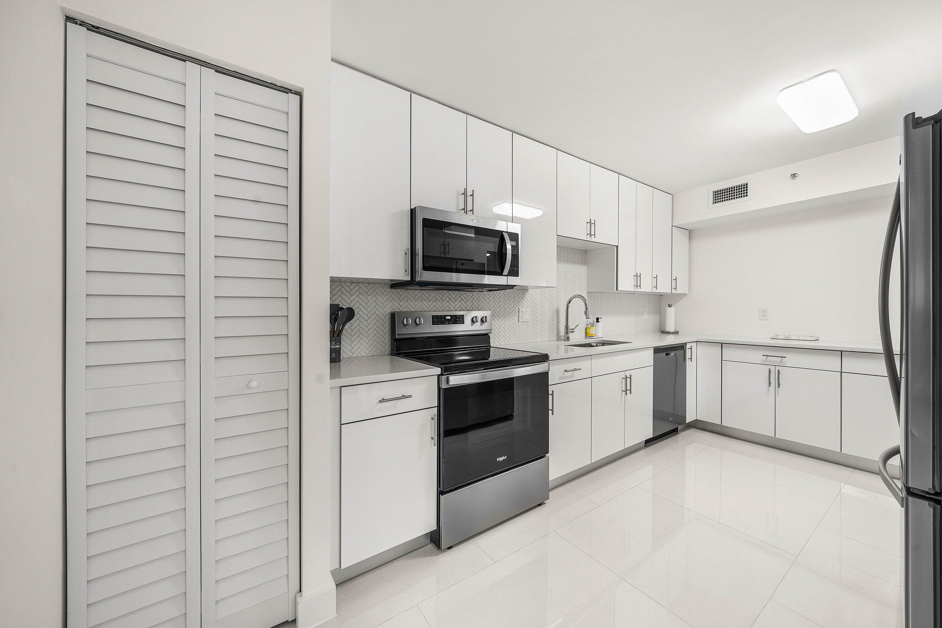 7145 Promenade Drive, Unit 101 Boca Raton, FL 33433 - Photo 12 of 35 a kitchen with a refrigerator stove and a sink