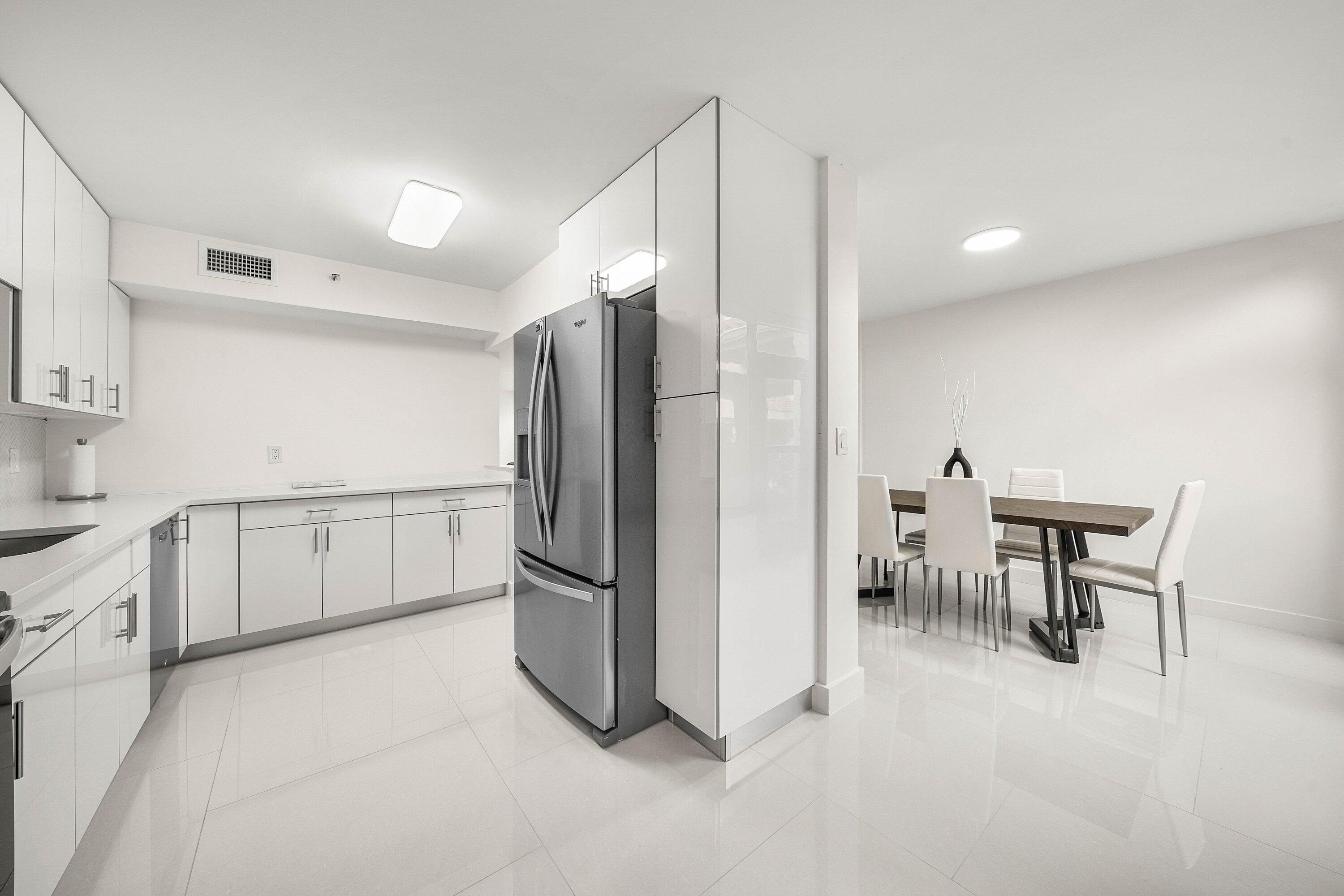 7145 Promenade Drive, Unit 101 Boca Raton, FL 33433 - Photo 13 of 35 a kitchen with white cabinets and stainless steel appliances