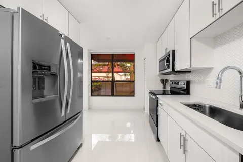 a kitchen with stainless steel appliances granite countertop a refrigerator and a stove