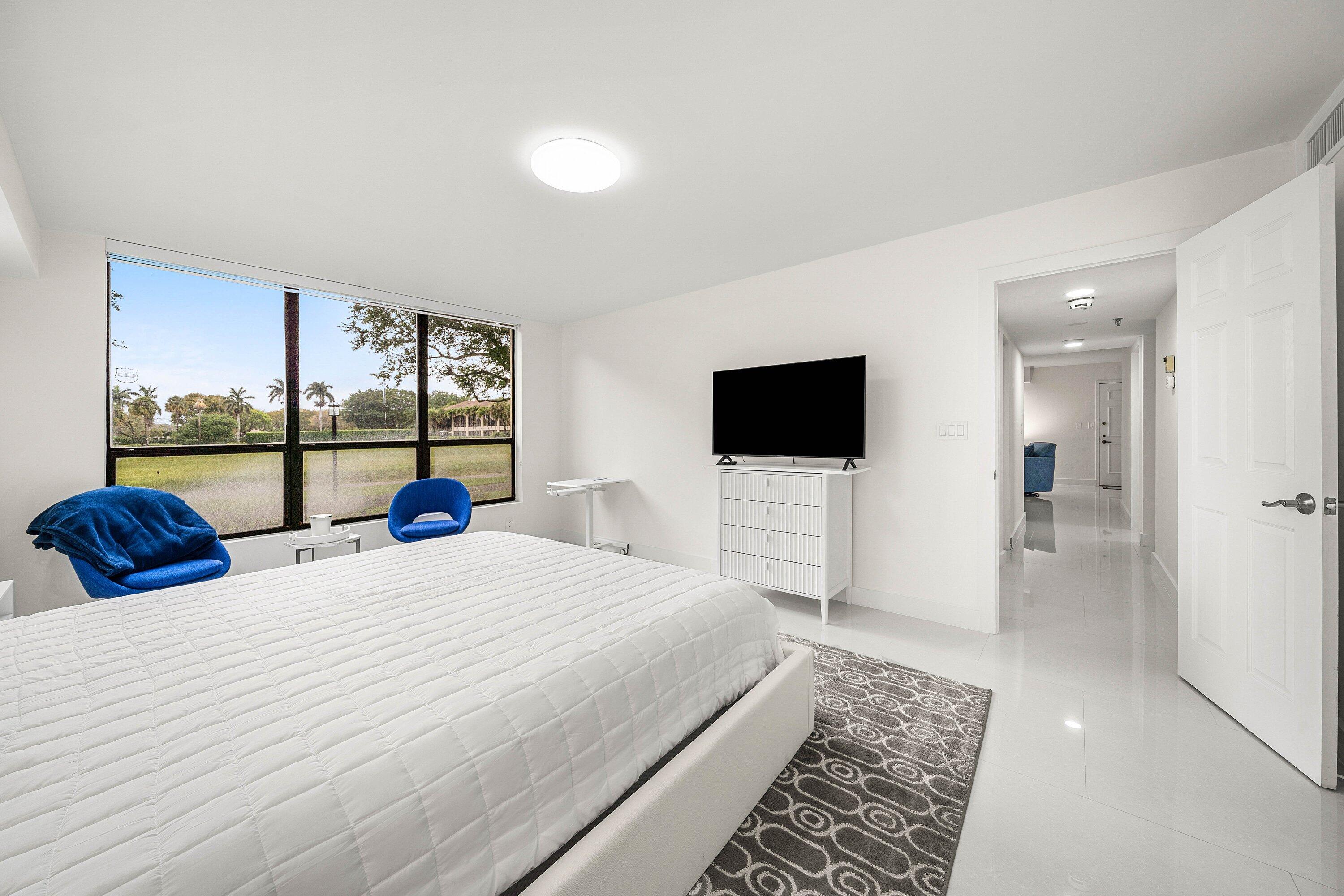 7145 Promenade Drive, Unit 101 Boca Raton, FL 33433 - Photo 18 of 35 a bedroom with a bed and a flat screen tv