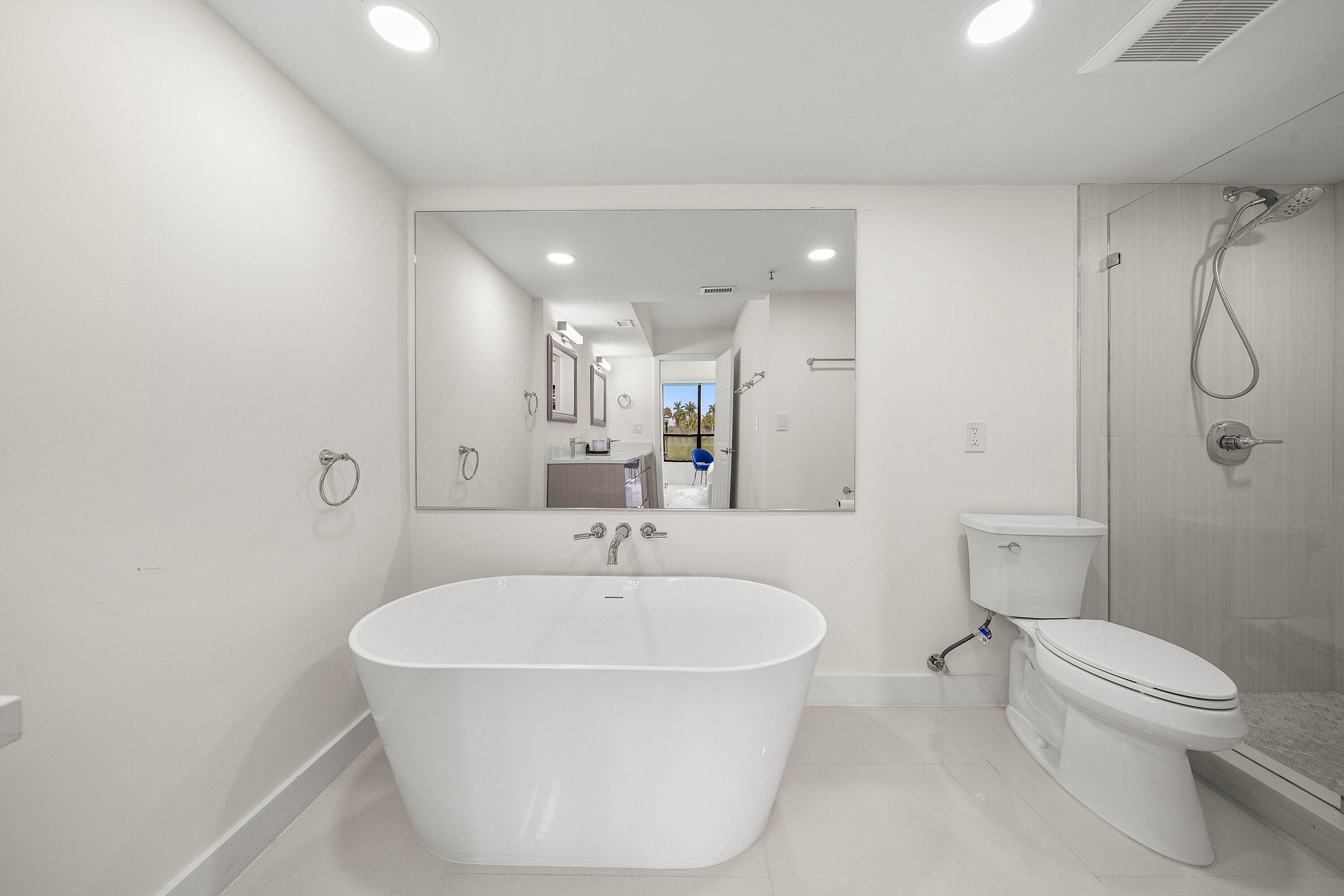 7145 Promenade Drive, Unit 101 Boca Raton, FL 33433 - Photo 22 of 35 a bathroom with a white bath tub a toilet and a sink