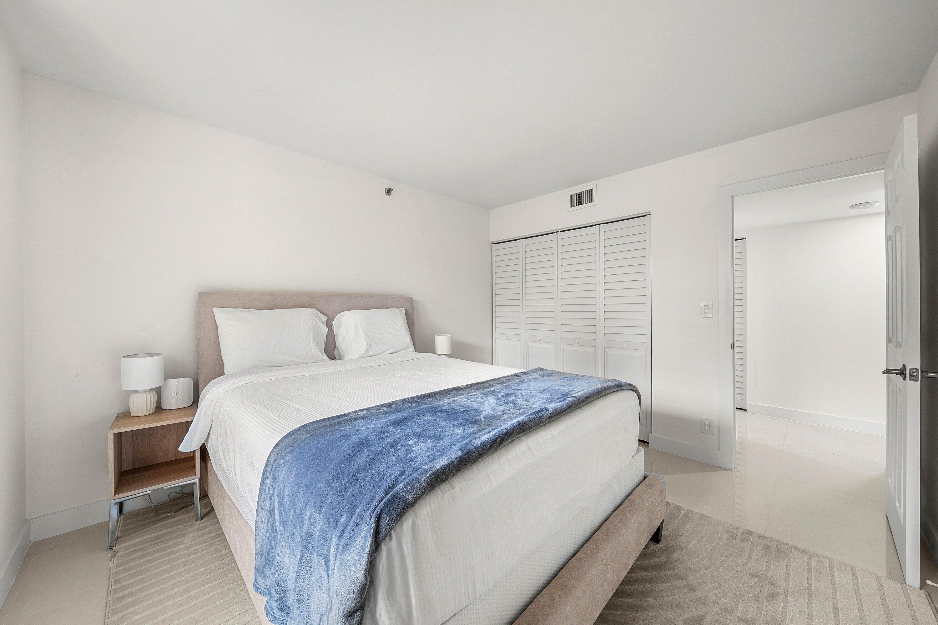 7145 Promenade Drive, Unit 101 Boca Raton, FL 33433 - Photo 26 of 35 a bedroom with a bed and a mirror