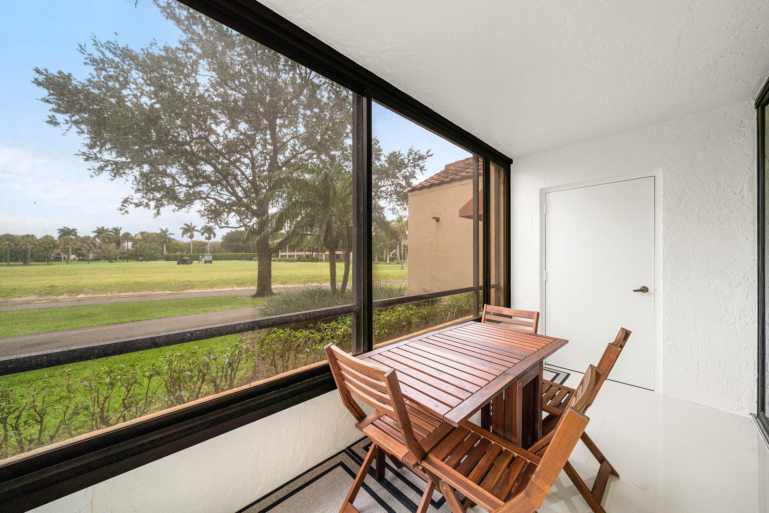7145 Promenade Drive, Unit 101 Boca Raton, FL 33433 - Photo 28 of 35 a view of a patio with wooden floor table and chairs
