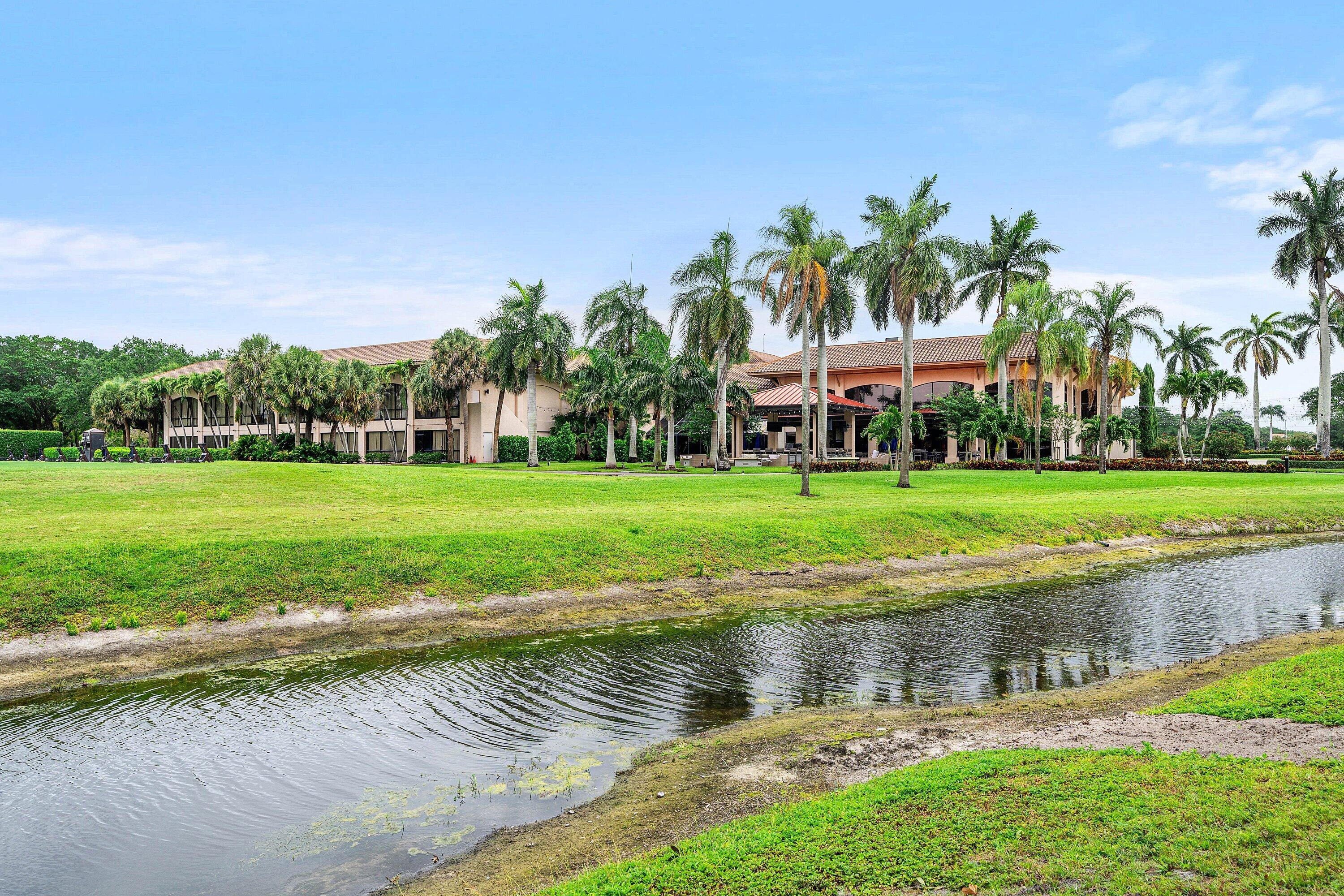 7145 Promenade Drive, Unit 101 Boca Raton, FL 33433 - Photo 31 of 35 a view of a lake with a yard and palm trees