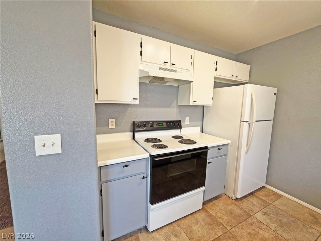 1444 Star Road, Unit 3 Pahrump, NV 89048 - Photo 22 of 35 A well-equipped kitchen features a functional range and a classic refrigerator set against practical tile flooring.