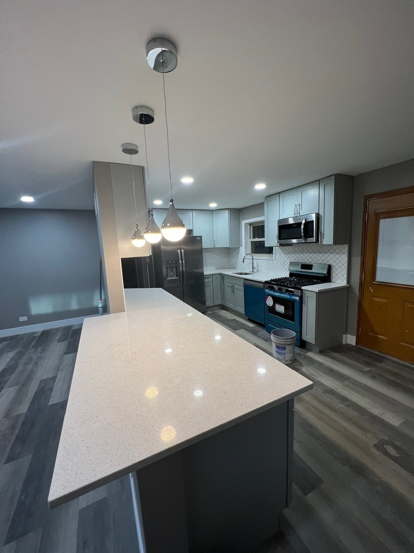 1631 Dundee Road Northbrook, IL 60062 - Photo 5 of 20 a large kitchen with kitchen island a sink a stove a oven a dining table and chairs