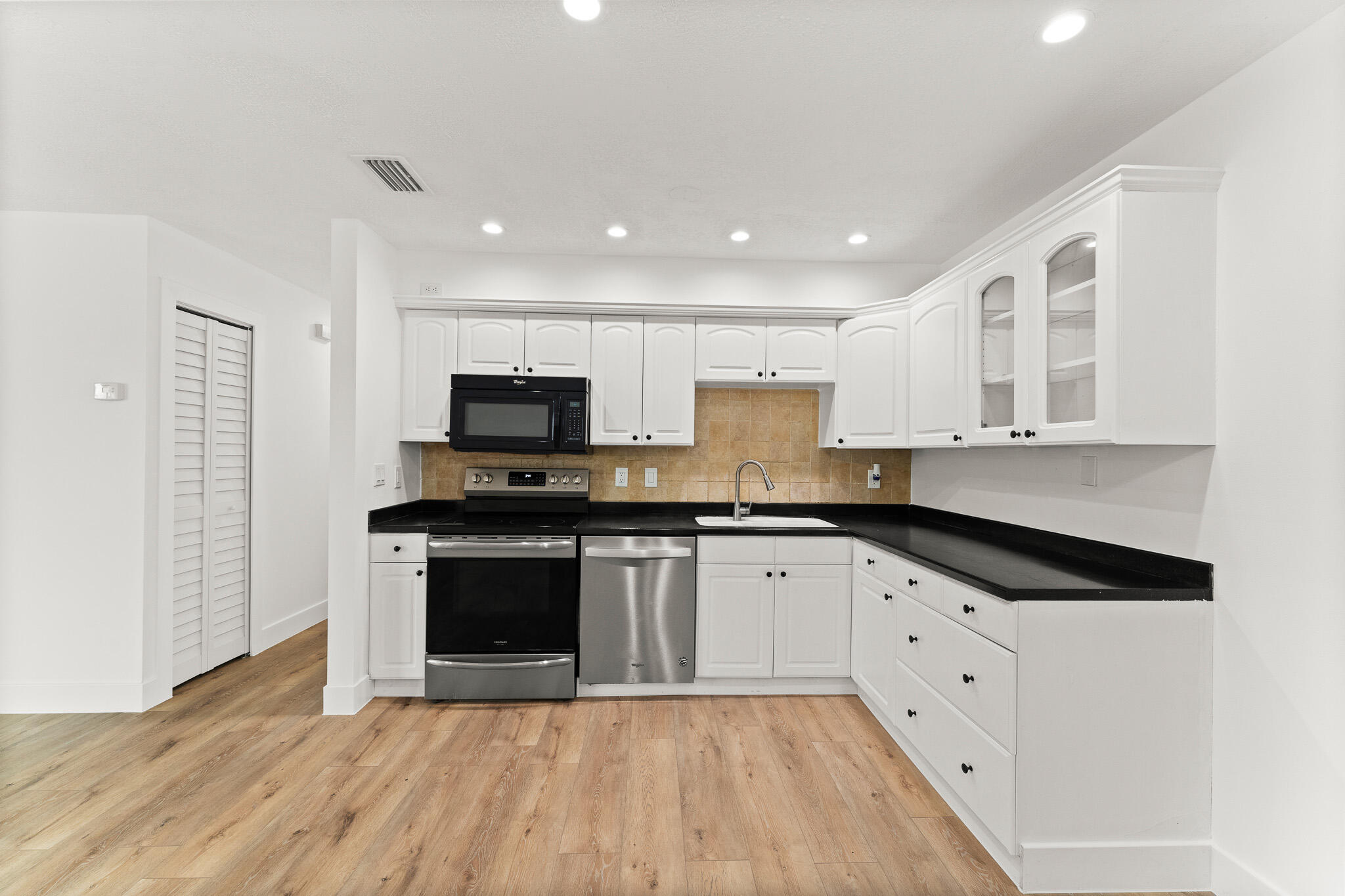 1575 Southwest Fresno Road Port St. Lucie, FL 34953 - Photo 11 of 27 a kitchen with granite countertop a stove top oven sink and cabinets