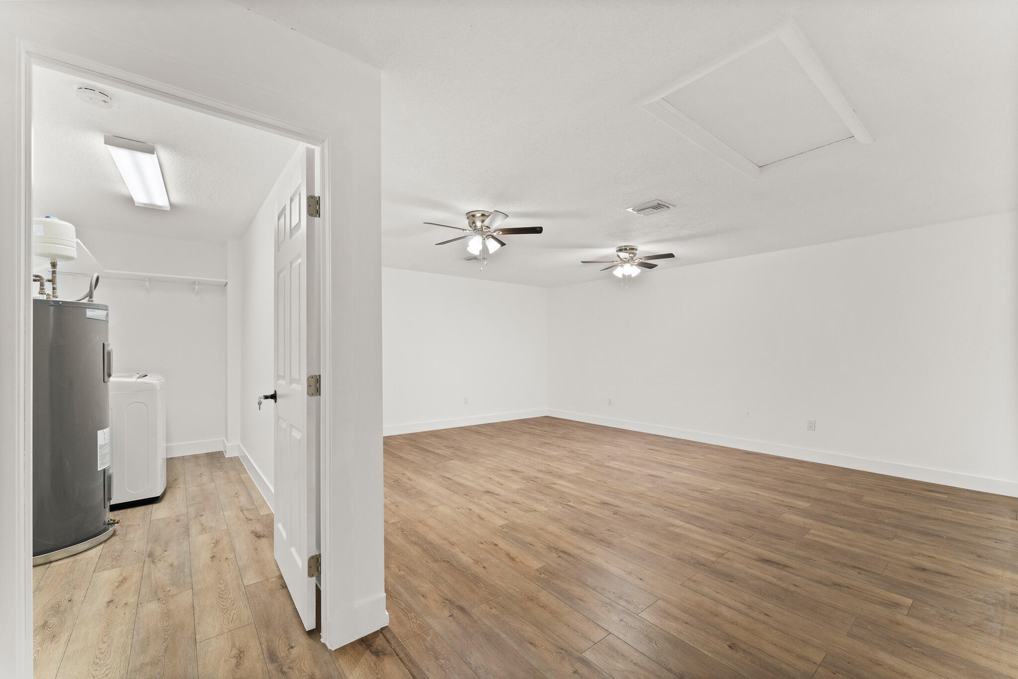 1575 Southwest Fresno Road Port St. Lucie, FL 34953 - Photo 14 of 27 an empty room with wooden floor and a ceiling fan