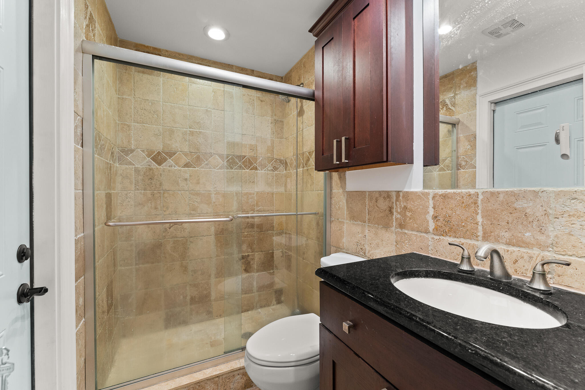 1575 Southwest Fresno Road Port St. Lucie, FL 34953 - Photo 22 of 27 a bathroom with a granite countertop sink toilet a mirror a vanity and shower
