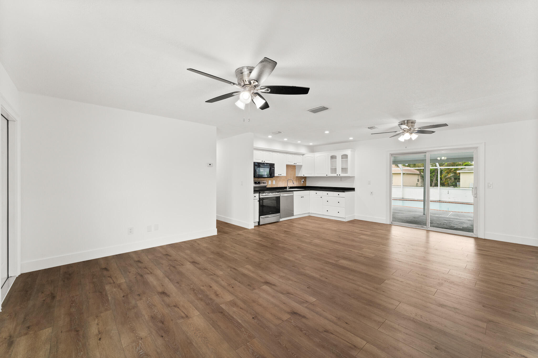1575 Southwest Fresno Road Port St. Lucie, FL 34953 - Photo 8 of 27 a view of a kitchen with wooden floor and a kitchen