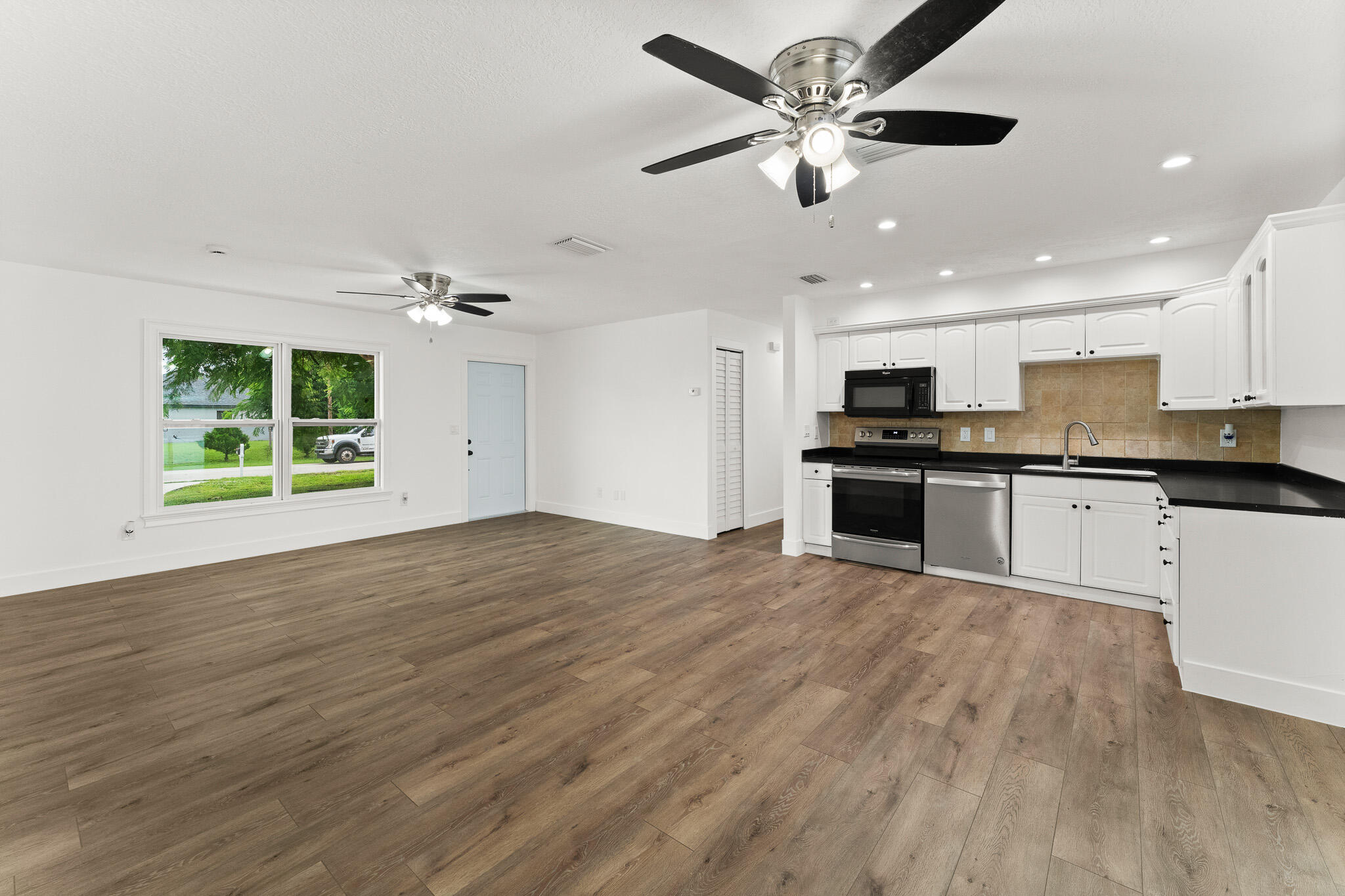1575 Southwest Fresno Road Port St. Lucie, FL 34953 - Photo 10 of 27 an empty room with wooden floor and a ceiling fan