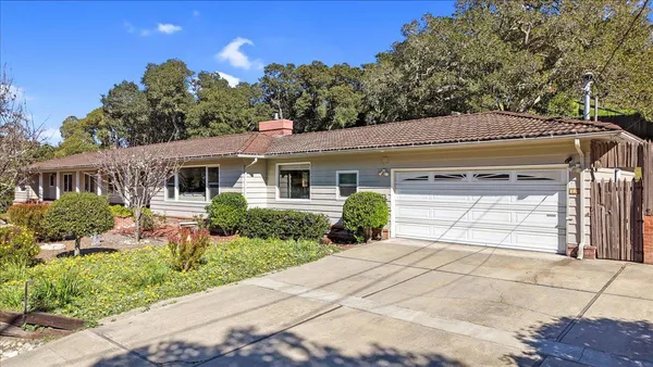 a front view of a house with a yard and potted plants