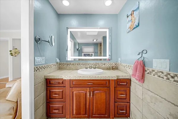 a bathroom with a tub a sink and mirror