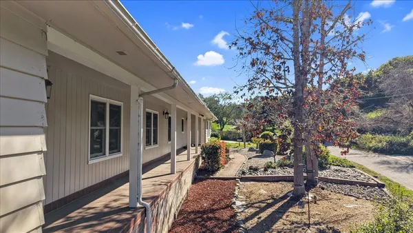 a view of a house with backyard and sitting area