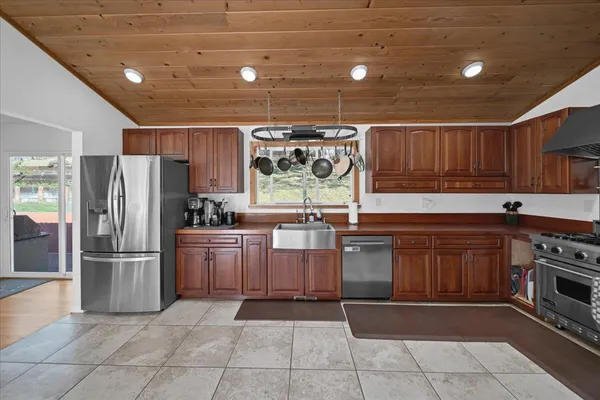a large kitchen with stainless steel appliances granite countertop a sink and cabinets
