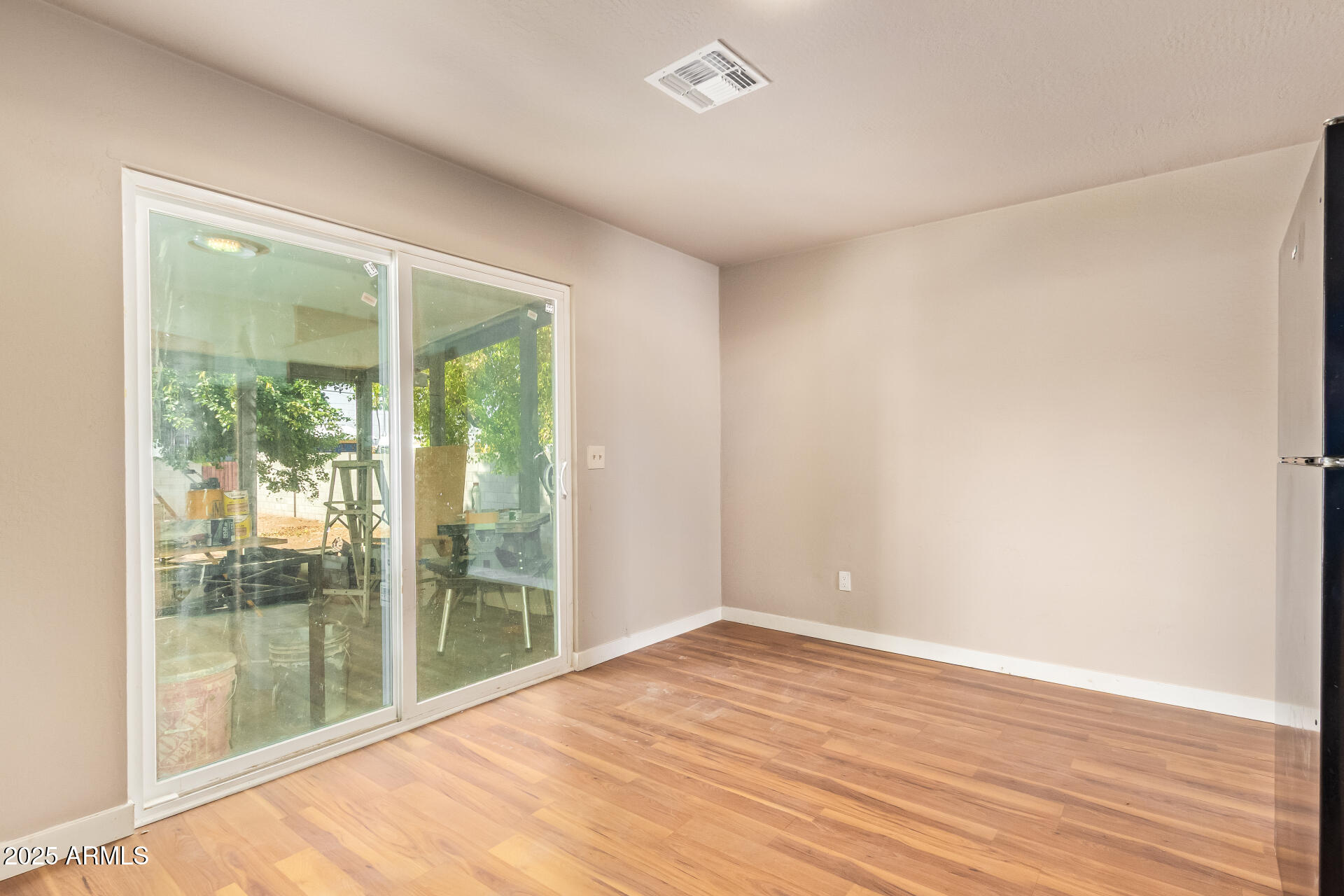 3527 West Almeria Road Phoenix, AZ 85009 - Photo 13 of 32 a view of an empty room with wooden floor and a window