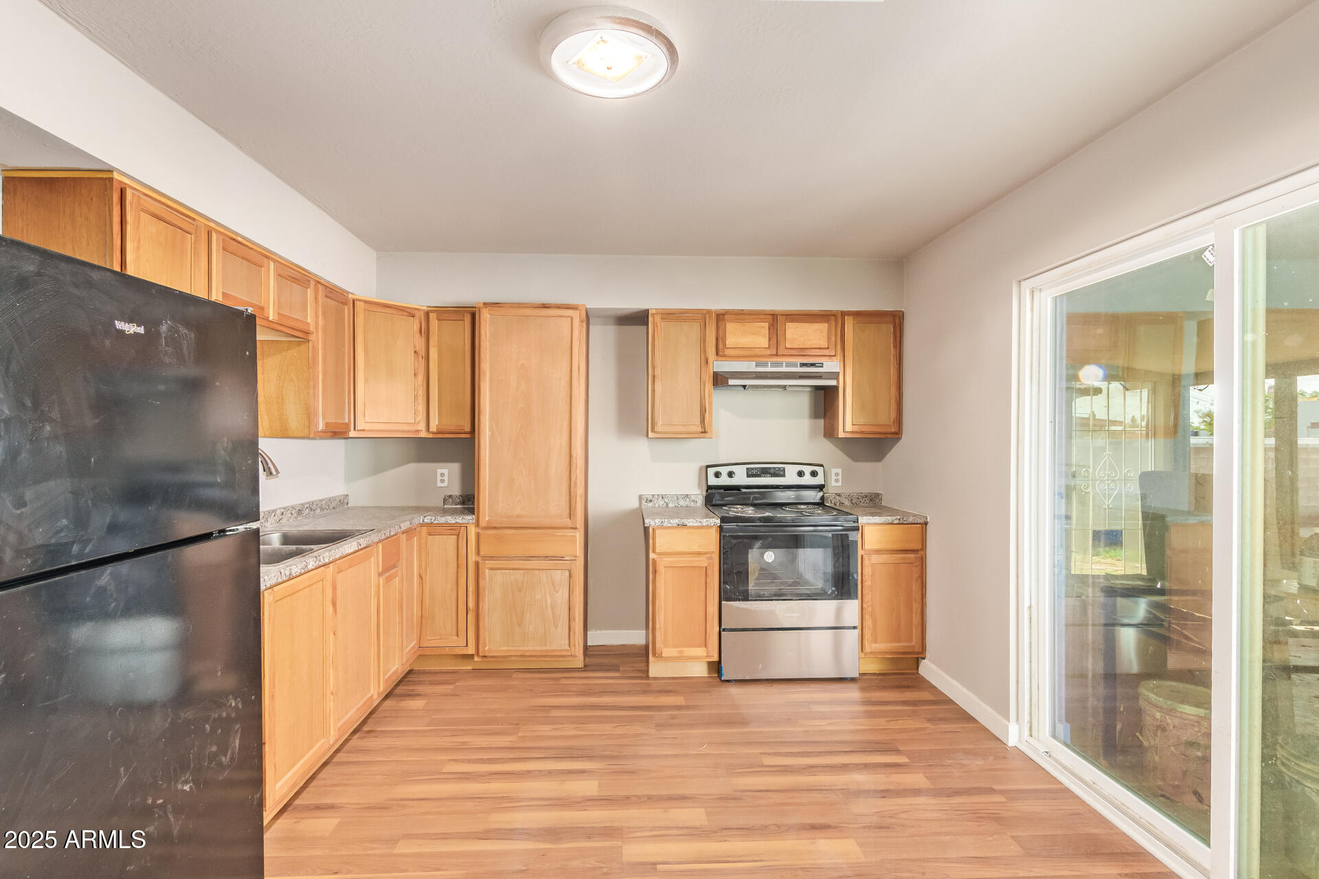 3527 West Almeria Road Phoenix, AZ 85009 - Photo 17 of 32 a kitchen with stainless steel appliances granite countertop a refrigerator a stove and a sink with large cabinets
