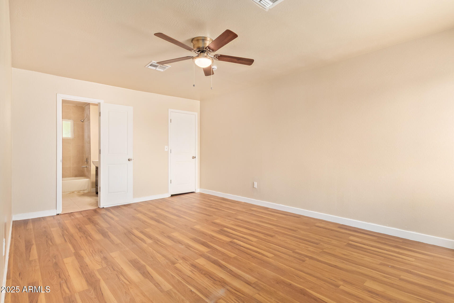 3527 West Almeria Road Phoenix, AZ 85009 - Photo 18 of 32 a view of a room with wooden floor and a ceiling fan