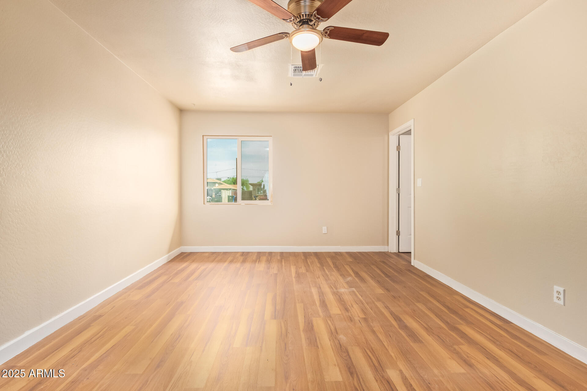 3527 West Almeria Road Phoenix, AZ 85009 - Photo 20 of 32 an empty room with a window and a ceiling fan