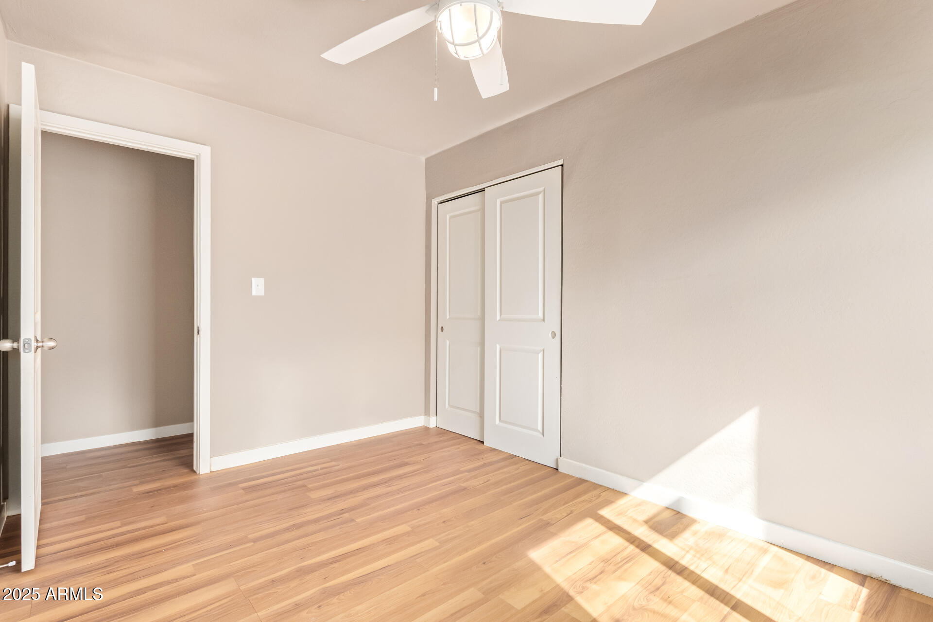 3527 West Almeria Road Phoenix, AZ 85009 - Photo 23 of 32 a view of a livingroom with wooden floor and a ceiling fan