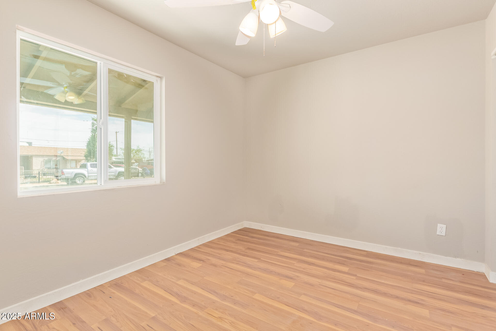 3527 West Almeria Road Phoenix, AZ 85009 - Photo 25 of 32 an empty room with wooden floor and windows