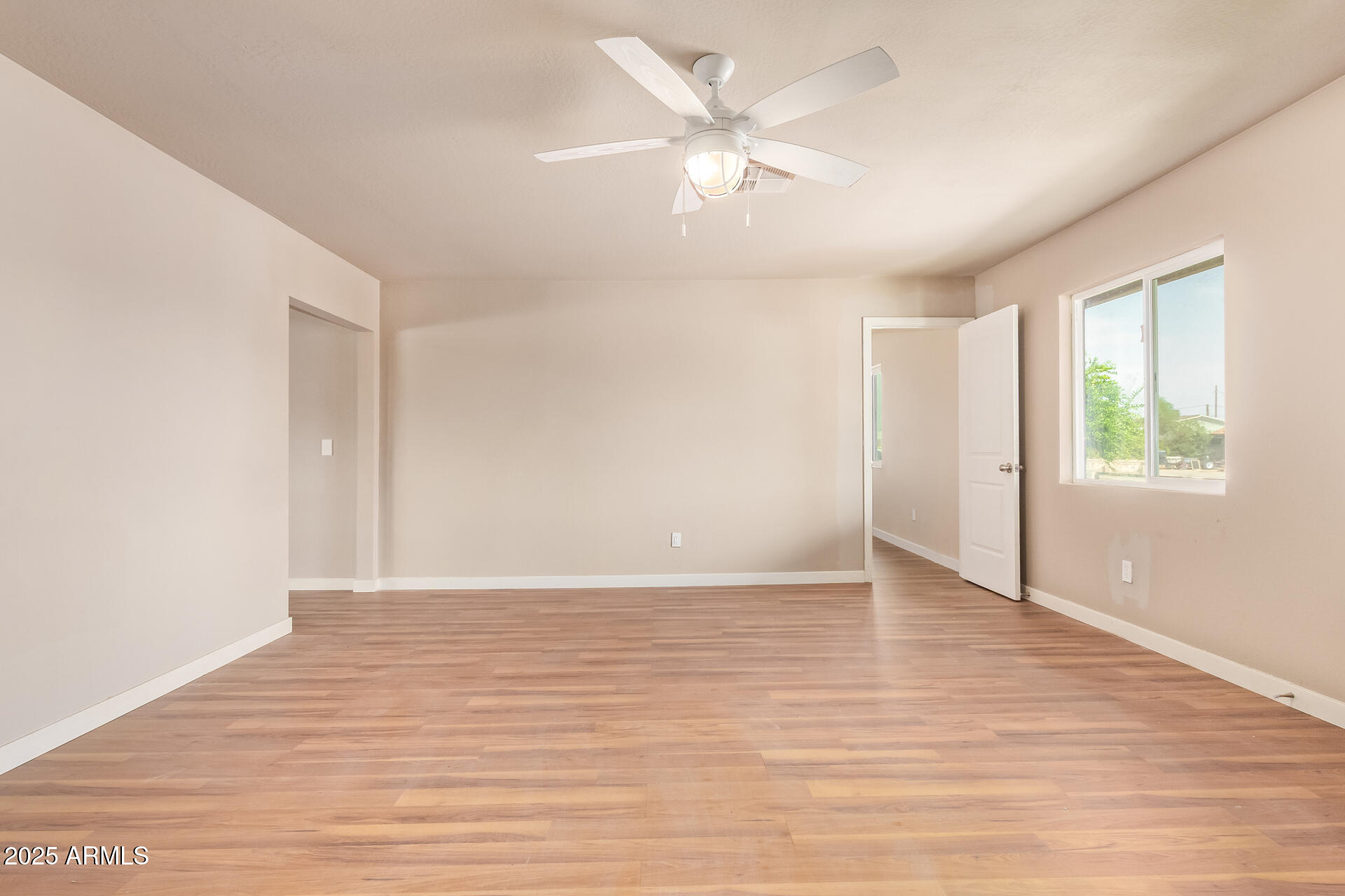 3527 West Almeria Road Phoenix, AZ 85009 - Photo 10 of 32 a view of an empty room with window and wooden floor