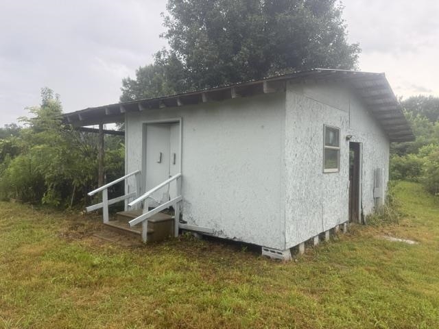 1100 Pine Top Road Toone, TN 38381 - Photo 35 of 40 Single-story structure with a covered entry, exposed rafter tails, wood siding, and an elevated foundation
