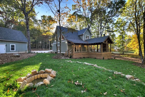 a view of a house with a yard swing and a tree
