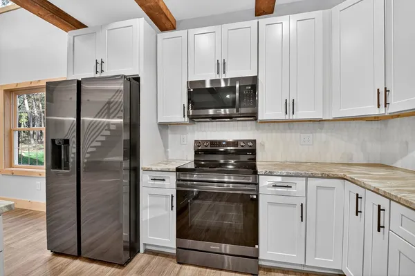 a kitchen with stainless steel appliances granite countertop a stove a refrigerator and a sink