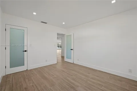 a view of an empty room with wooden floor