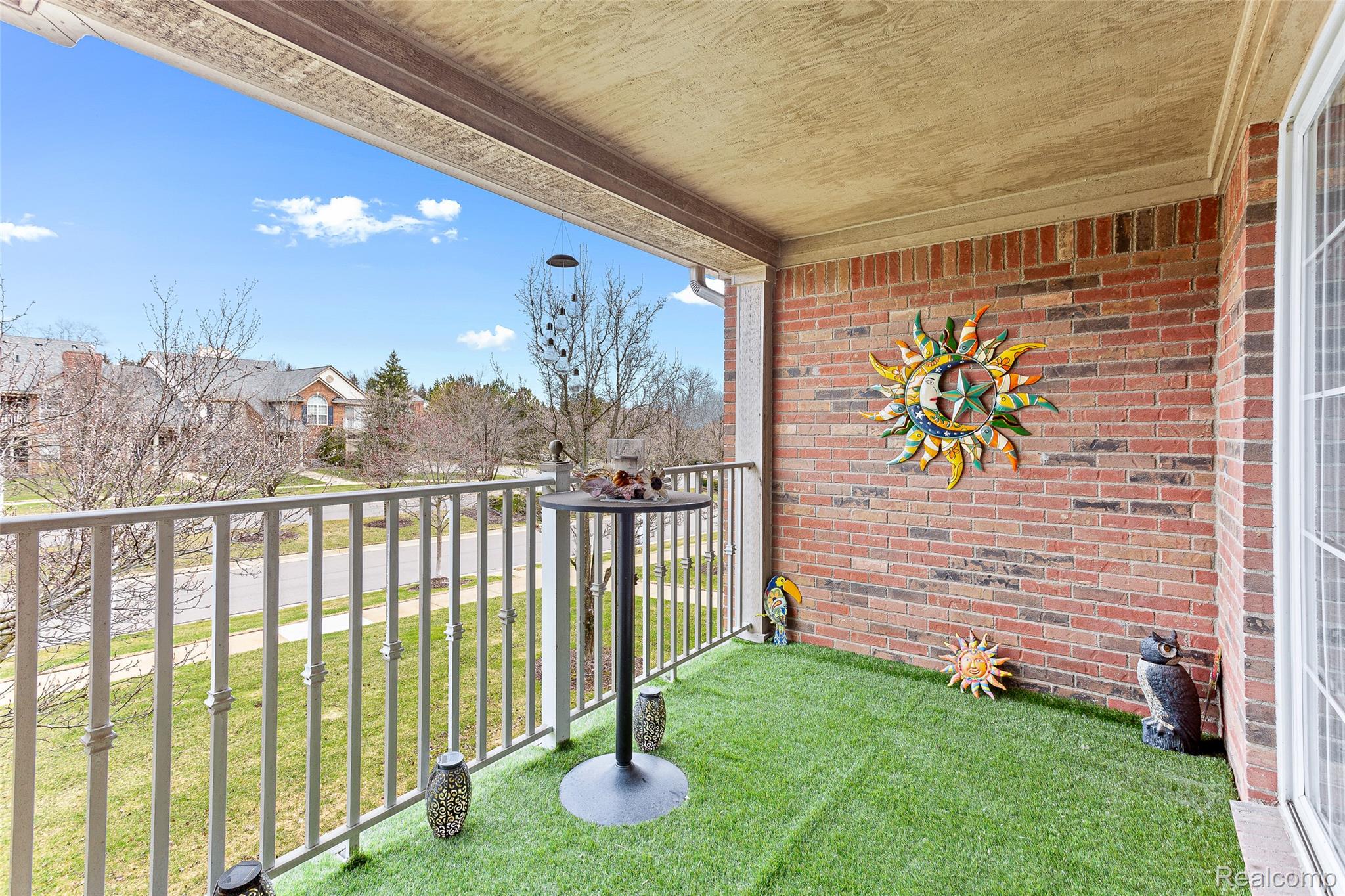 3553 Oakmonte Boulevard Rochester, MI 48306 - Photo 31 of 42 Outdoor balcony featuring a brick accent wall, white railings, and a faux grass floor