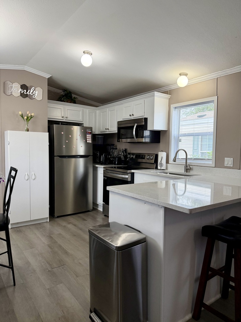 8800 South Harlem Avenue, Unit 2111 Bridgeview, IL 60455 - Photo 2 of 11 a kitchen with kitchen island a refrigerator sink and wooden floor
