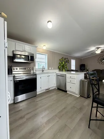 a kitchen with granite countertop a sink cabinets and stainless steel appliances