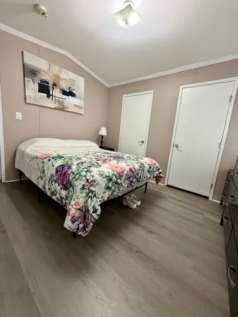 a bedroom with a bed painting on the wall and a window
