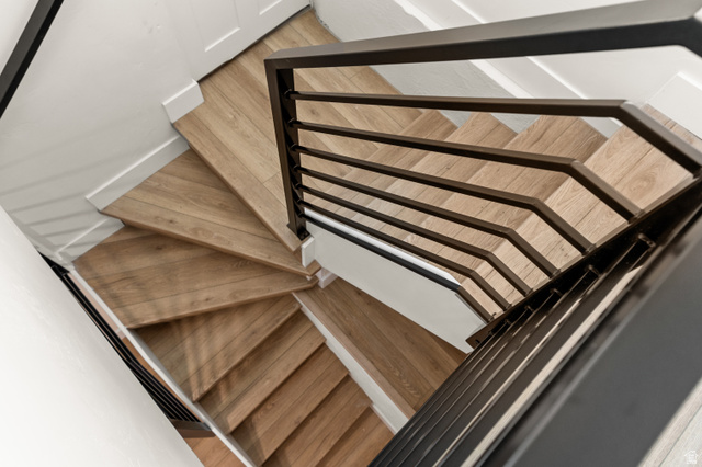 189 West Center Street Midvale, UT 84047 - Photo 29 of 64 Staircase featuring light wood-finish treads, white risers, and black metal railings with horizontal spindles