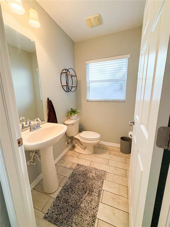 12715 Saulston Place Hudson, FL 34669 - Photo 22 of 44 a bathroom with a sink a toilet a mirror and shower curtain