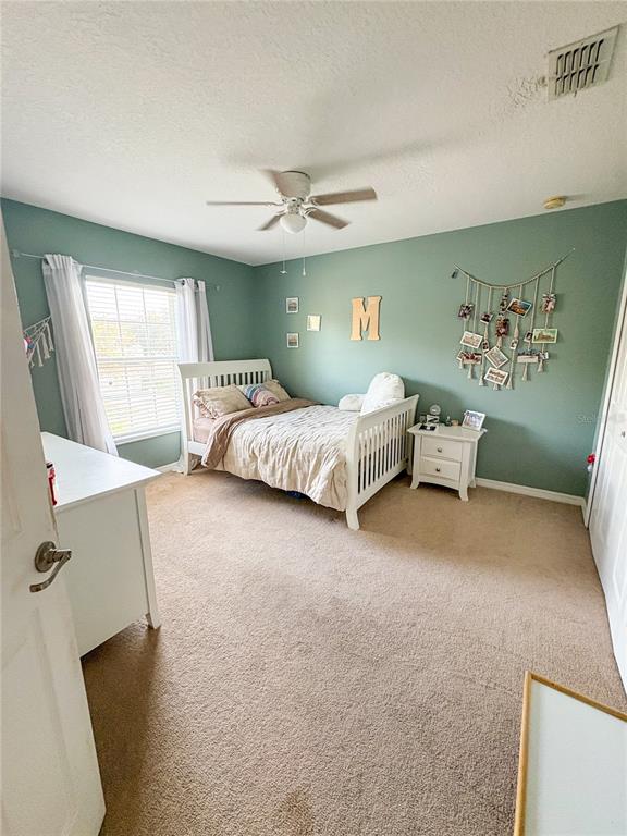12715 Saulston Place Hudson, FL 34669 - Photo 23 of 44 a bedroom with a bed and a chandelier