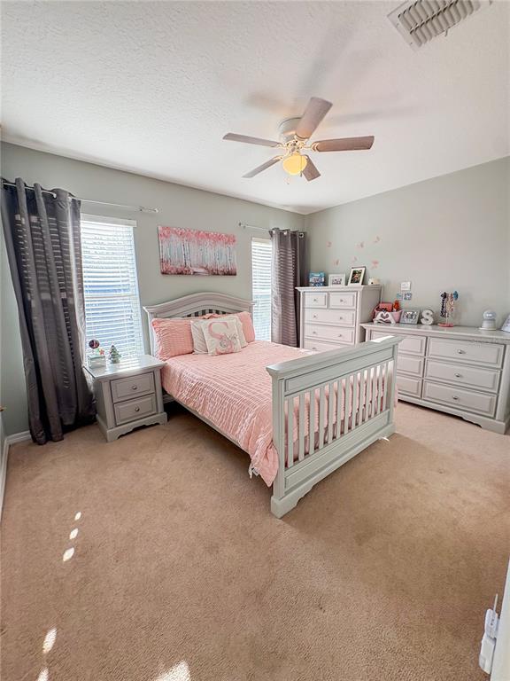 12715 Saulston Place Hudson, FL 34669 - Photo 28 of 44 a bedroom with a bed couch and a window