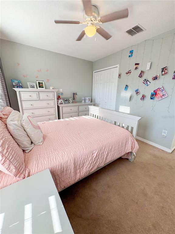 12715 Saulston Place Hudson, FL 34669 - Photo 29 of 44 a bedroom with double bed and a chandelier