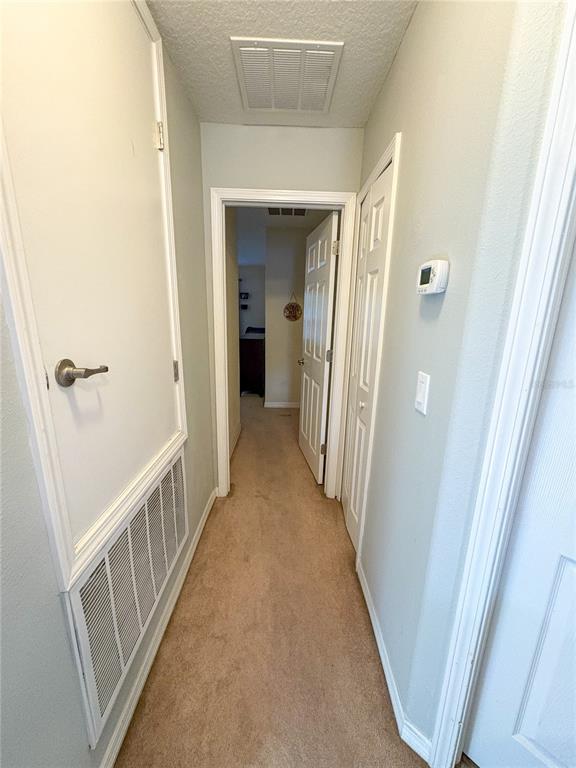 12715 Saulston Place Hudson, FL 34669 - Photo 31 of 44 a view of a hallway with wooden floor and staircase