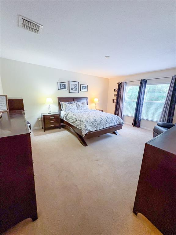 12715 Saulston Place Hudson, FL 34669 - Photo 32 of 44 a bedroom with a bed and wooden floor