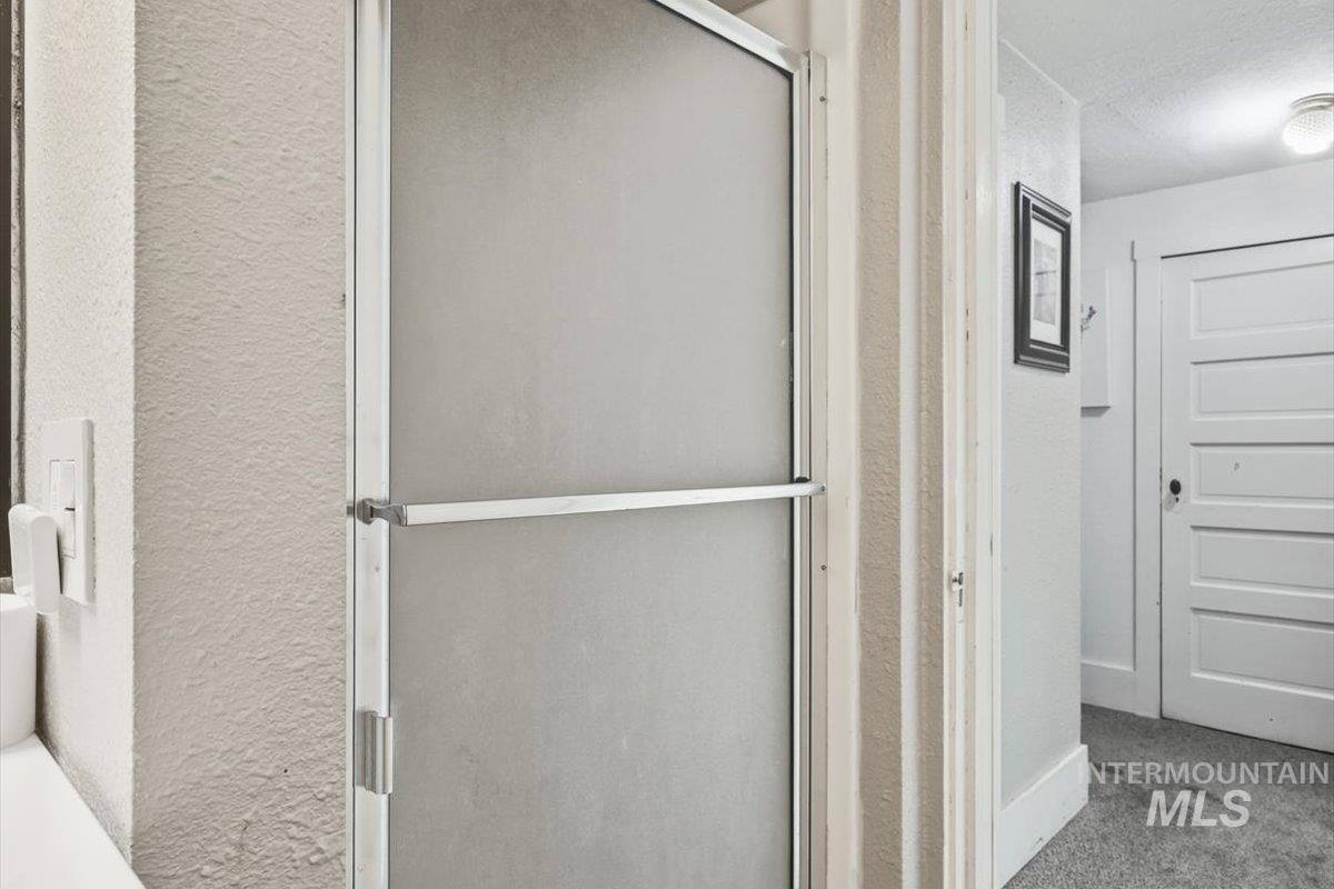 148 Glascock Road Weiser, ID 83672 - Photo 26 of 32 Bathroom featuring a stall shower, a textured wall, a textured ceiling, and carpet floors