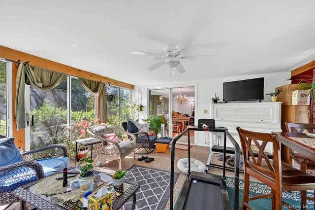 a living room with furniture a flat screen tv and a floor to ceiling window