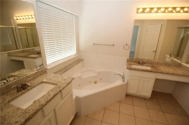 a bathroom with a granite countertop sink a mirror and a bathtub